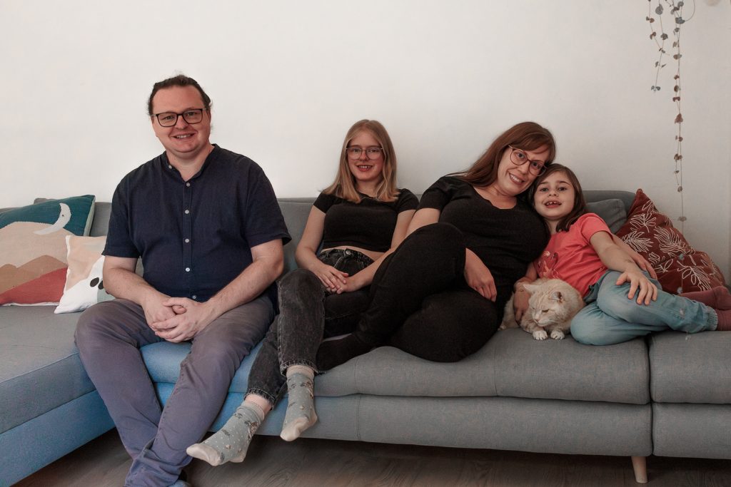 Familie posiert für ein Familienfoto auf dem Sofa
