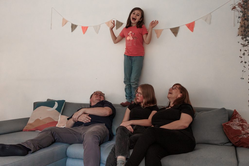 ungestellte Familienmomente im Wohnzimmer auf dem Sofa